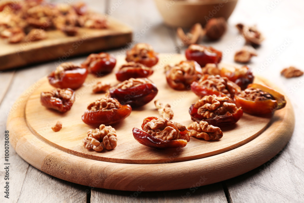 Walnut, date fruit on wooden table, close-up Walnut, date fruit on wooden table, close-up