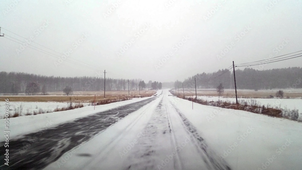 Driving on a country field highway, in terrible snow weather and frozen road Driving on a country field highway, in terrible snow weather and frozen road