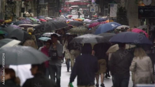 Crowded street with people walking holding umbrellas in rain, slow motion, Rome Italy