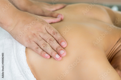 Closeup womans upper back with hands working on giving massage, spa treatment concept