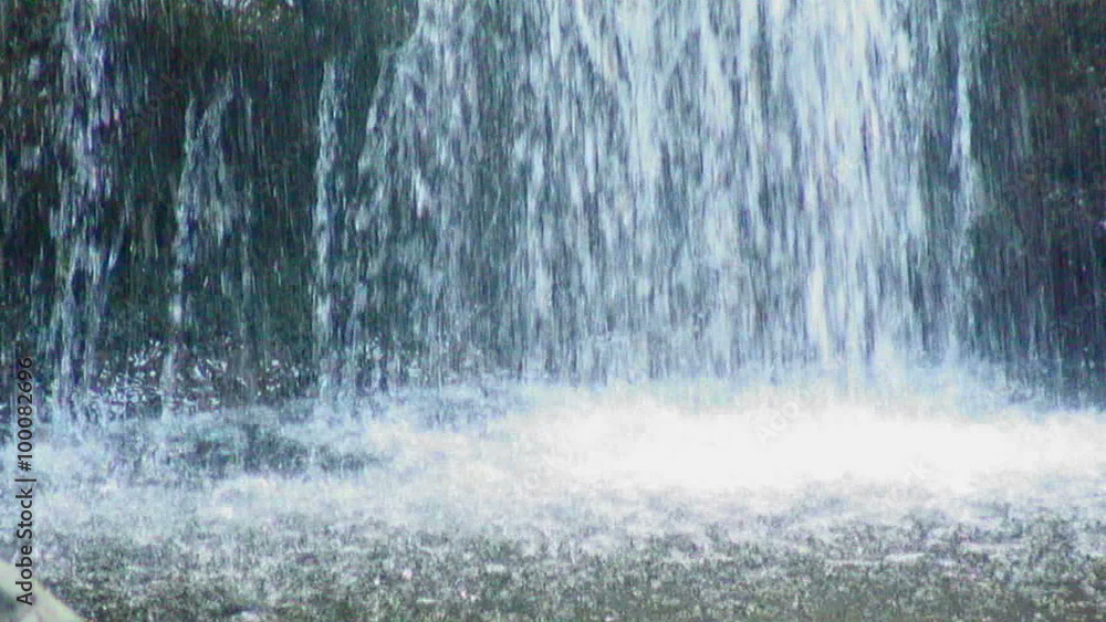 Water from a waterfall splashing into a pond. Water from a waterfall splashing into a pond.