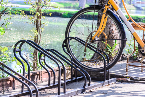 Close up of bicycle loacked with parking rack in city.