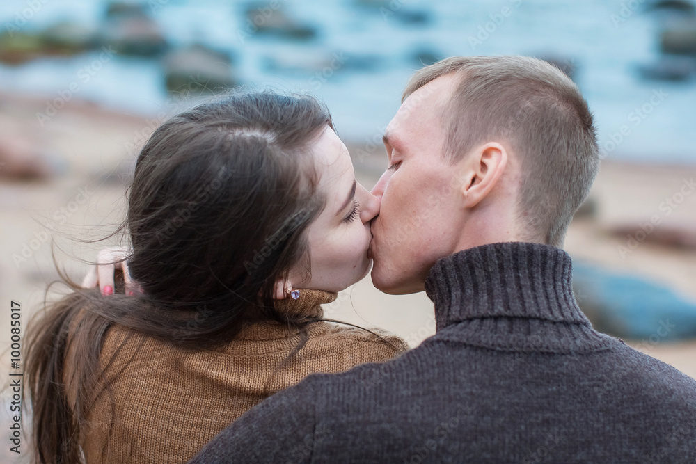 Loving couple hugging and kisses on the rocky beach Loving couple hugging and kisses on the rocky beach