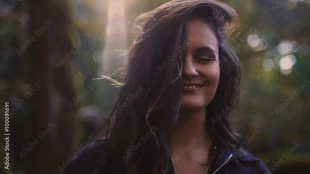 Beautiful girl in a forest throws leaves up in the air, slow motion, bokeh and lens flare Beautiful girl in a forest throws leaves up in the air, slow motion, bokeh and lens flare