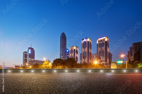 empty road and cityscape in blue sky at dawn