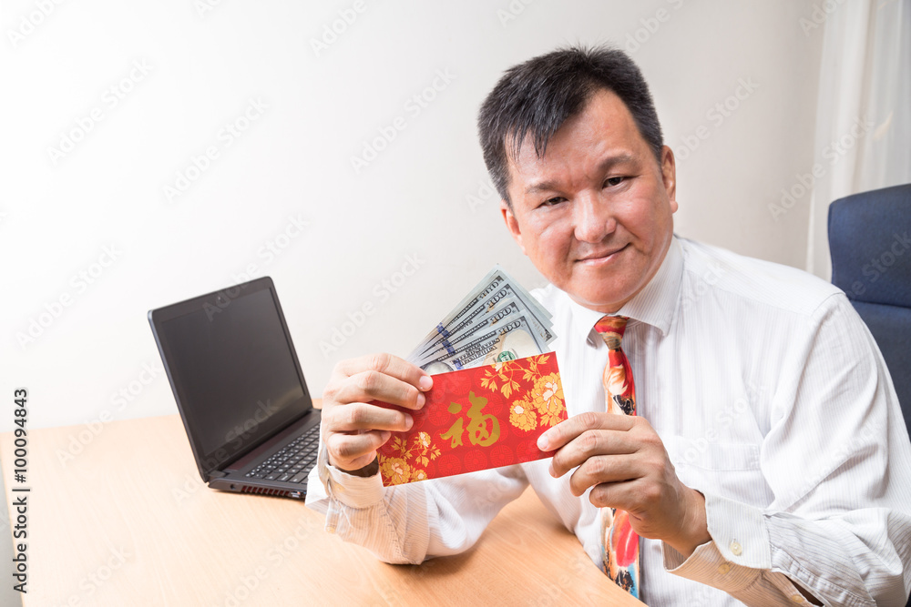 Employee displaying red packet with Good Fortune Chinese character, and money received during Chinese New Year in office Employee displaying red packet with Good Fortune Chinese character, and money received during Chinese New Year in office