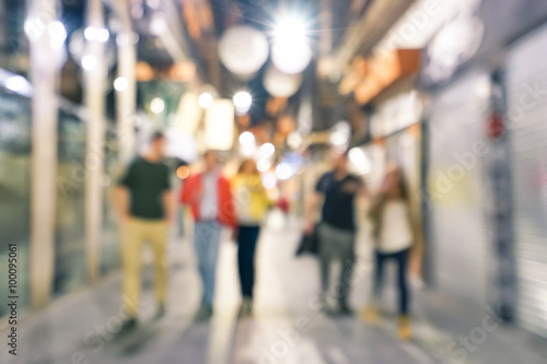 Blurred defocused abstract background of people walking on the street by night with - Nightlife concept with young friends hanging out together in city center - Cold neutral filtered look 