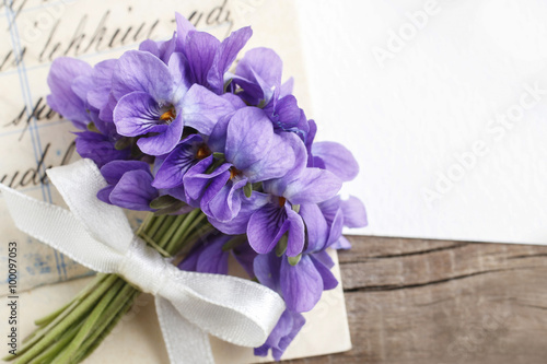 Foto Bouquet of violet flowers (viola odorata) and vintage letters