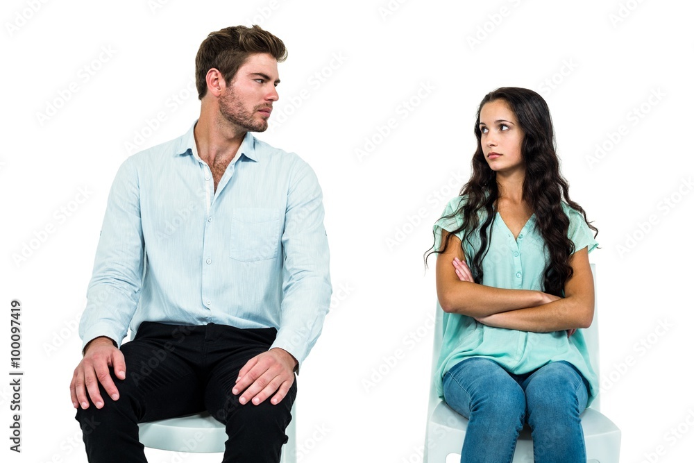 Couple sitting on chairs not talking after argument Couple sitting on chairs not talking after argument
