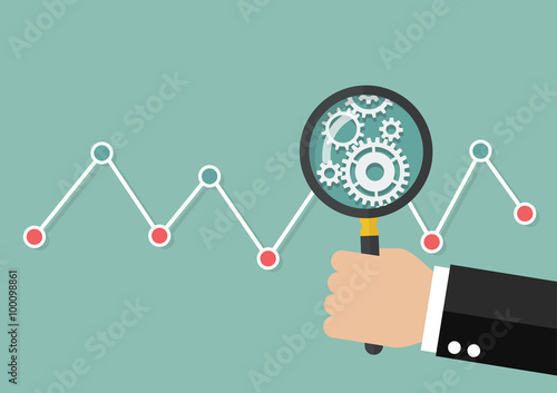 Hand holding magnifying glass with stock market graph