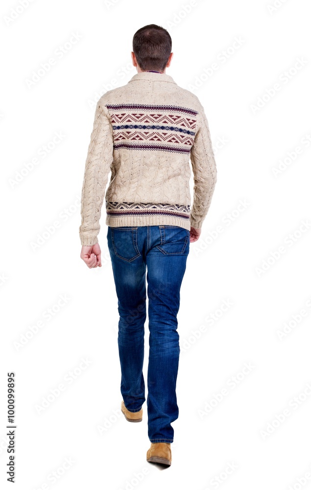 Back view of walking handsome man in jeans and warm sweater. . Back view of walking handsome man in jeans and warm sweater. .