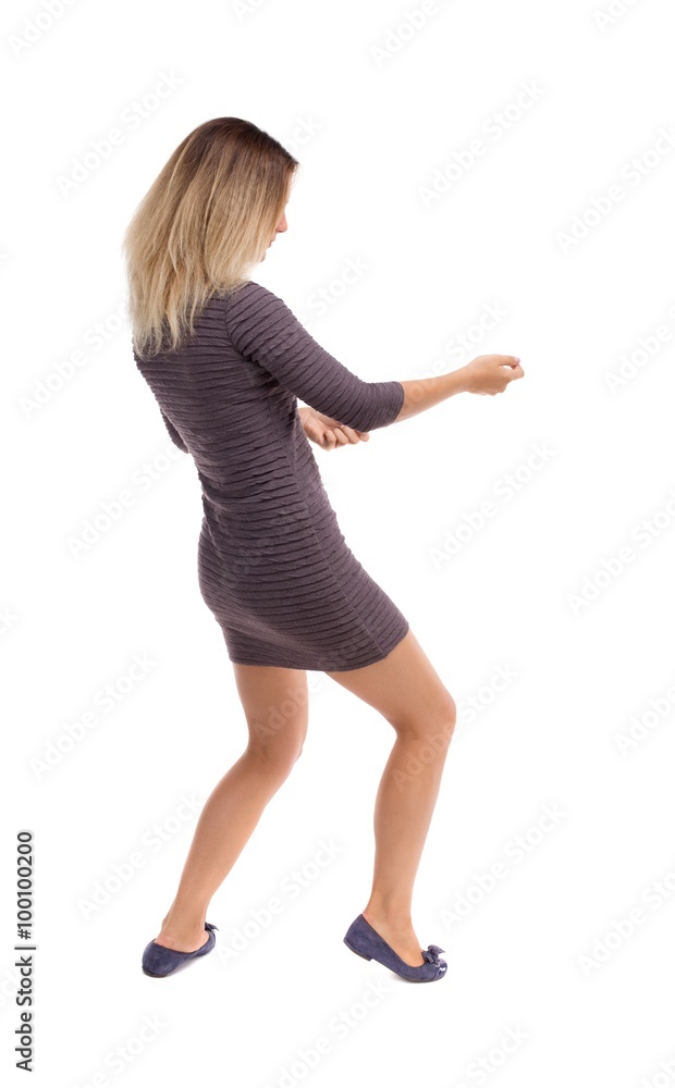 back view of standing girl pulling a rope from the top or cling back view of standing girl pulling a rope from the top or cling