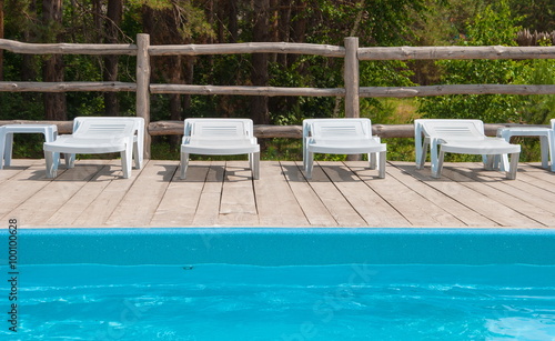 chaise lounges around the pool in the forest recreation area