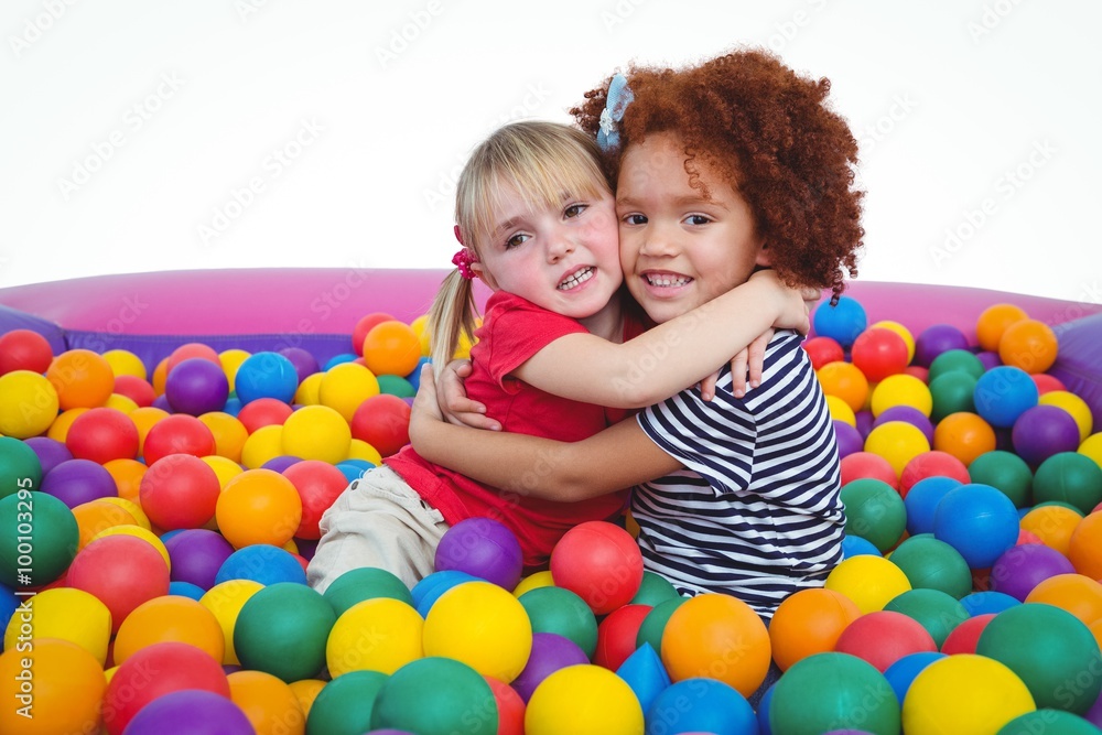 Cute smiling girls in sponge ball pool hugging Cute smiling girls in sponge ball pool hugging