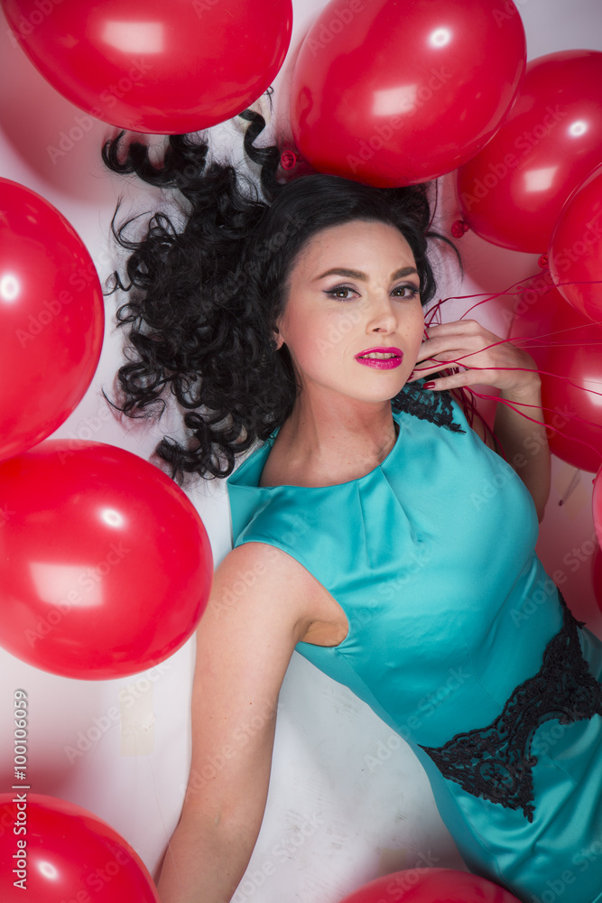 Happy young woman with red latex balloons