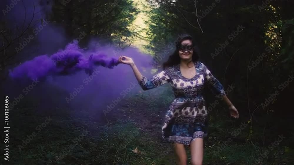 Beautiful girl in a mask runs and spins around with a purple smoke grenade, slow motion Beautiful girl in a mask runs and spins around with a purple smoke grenade, slow motion