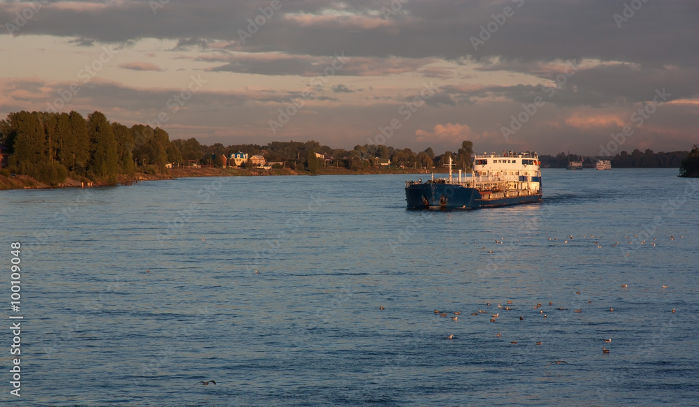 blue cargo ship at sunset