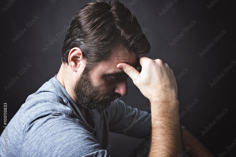 Low key portrait of man sitting in dark and contemplating Low key portrait of man sitting in dark and contemplating
