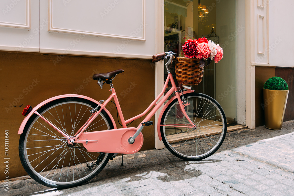 Vintage bicycle with a decorative basket of flowers parking on s