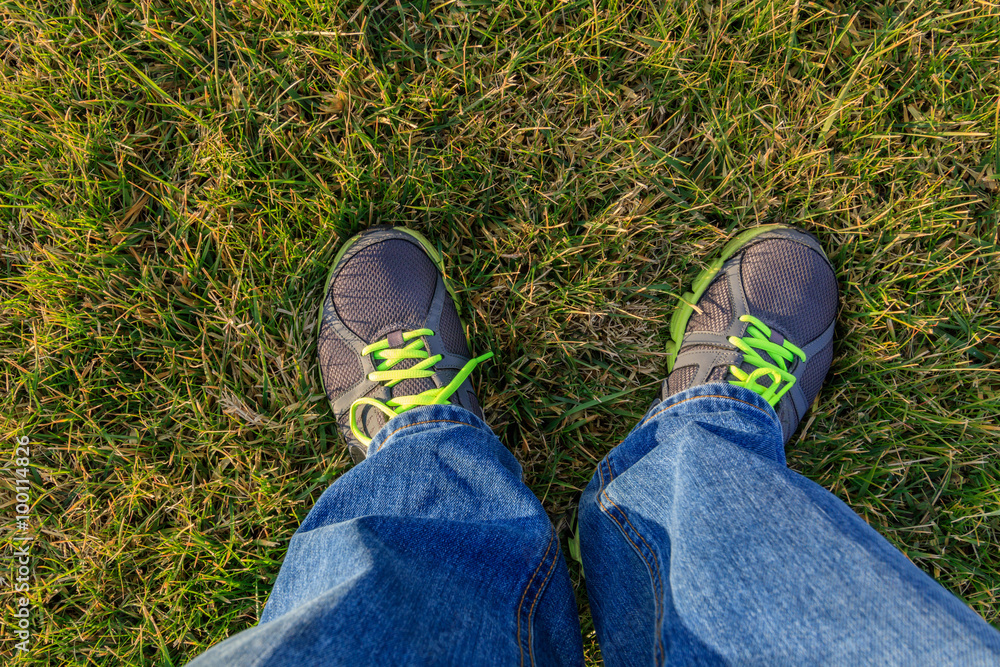 Men standing on the grass in jeans and sneakers