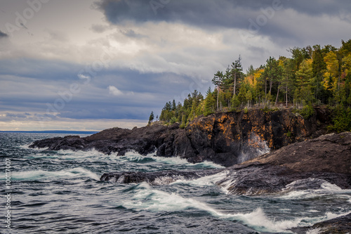 Fotografia, Obraz Lake Superior Coast, Gray sky and stormy seas crash on the cliffs of the black rocks along the shores of the Lake Superior coast