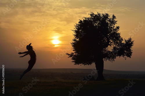 young happy woman on field in summer sunse