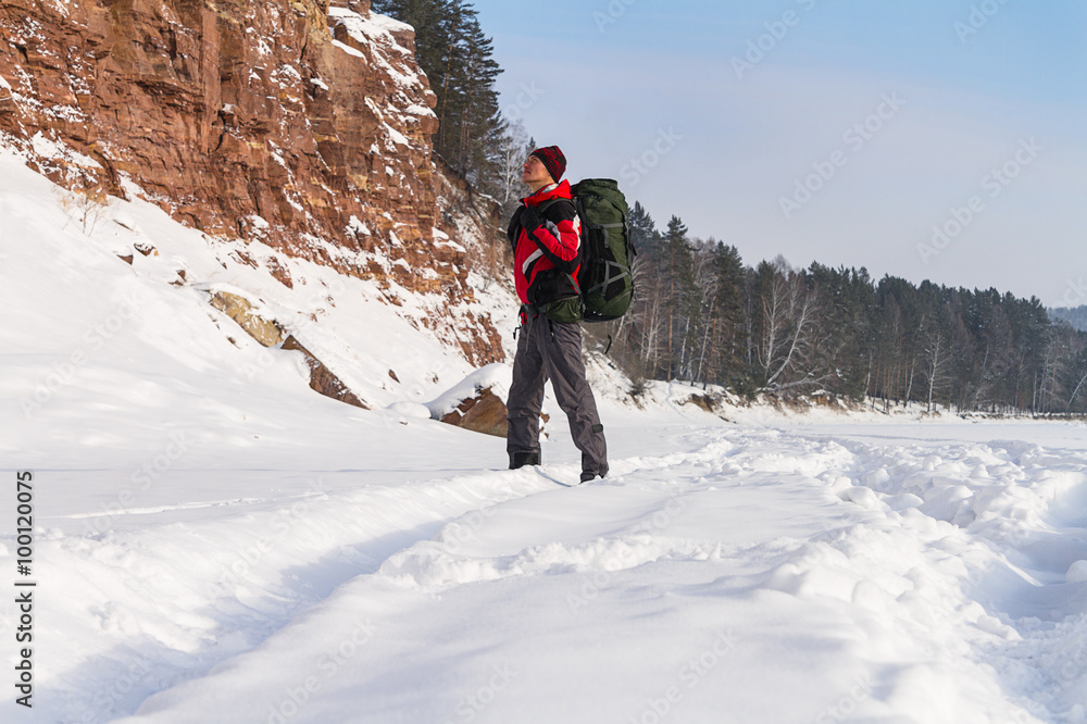 hiker looks at a rock, winter hiking, expedition
