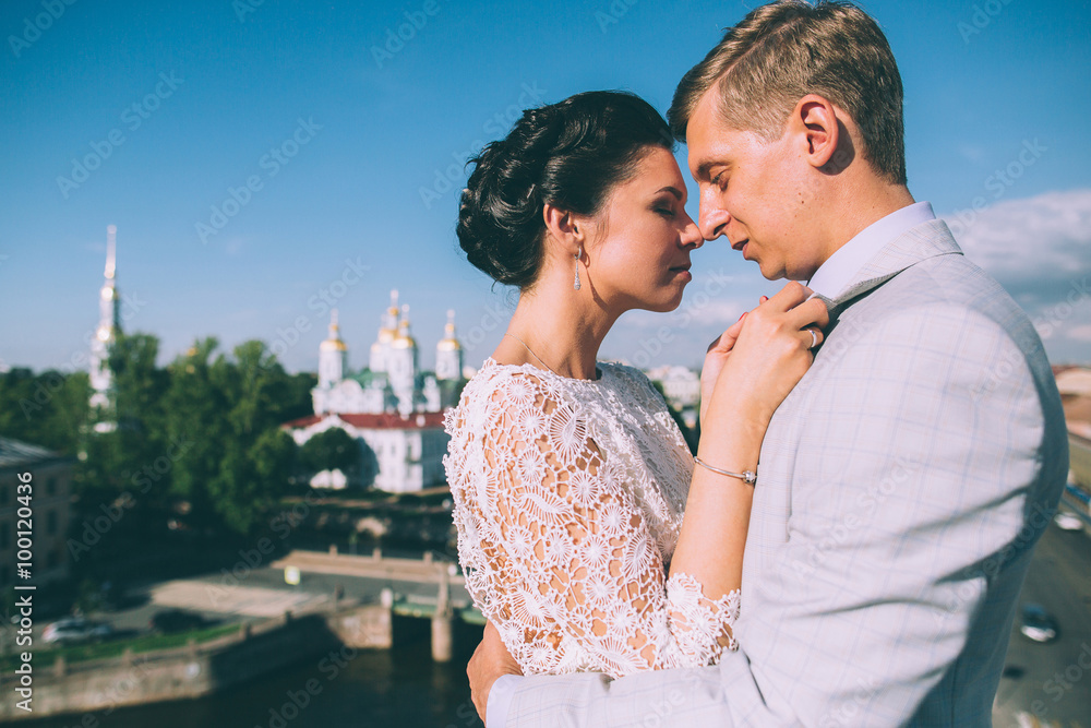 beautiful wedding couple together on the roof of a tall building