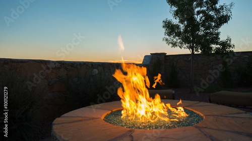 Patio Fireplace Rise and Lower to Sunset in Desert. up and rises over backyard stone and glass fireplace to reveal the sunset in the background. Second shot is lowering from the sunset to the fire.
 photo