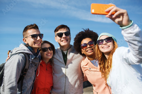 smiling friends taking selfie with smartphone © Syda Productions