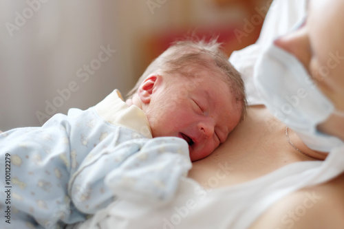One day old newborn baby with mother