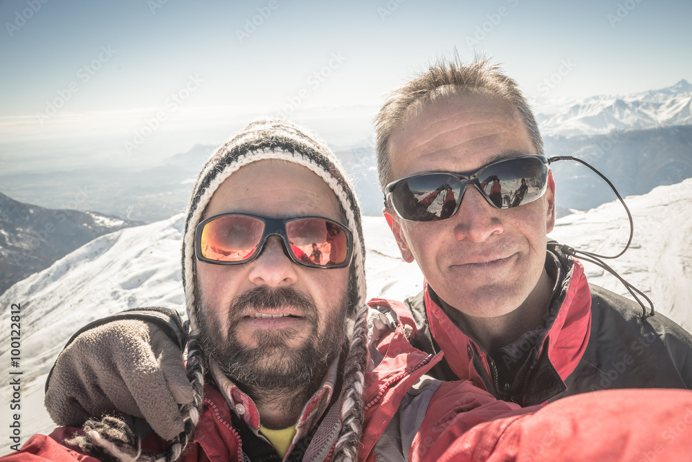 Selfie of two alpinists on the mountain top in winter