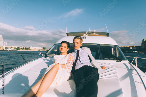 Happy bride and groom on a yacht traveling together on a warm summer day