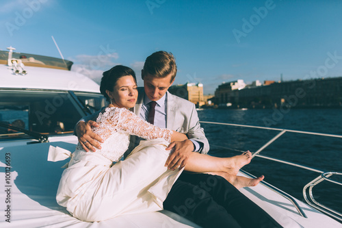 Happy bride and groom on a yacht traveling together on a warm summer day
