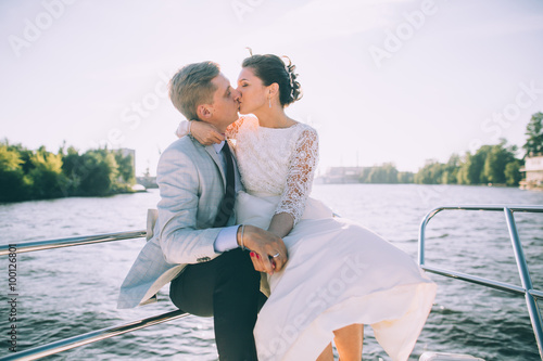 Happy bride and groom on a yacht traveling together on a warm summer day