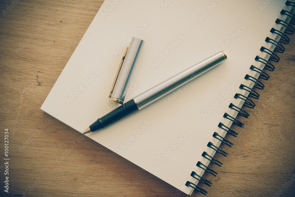 paper notebook and pen on a table with filter effect retro vinta paper notebook and pen on a table with filter effect retro vinta