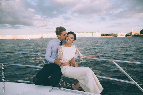 Happy bride and groom on a yacht traveling together on a warm summer day © cmirnovalexander