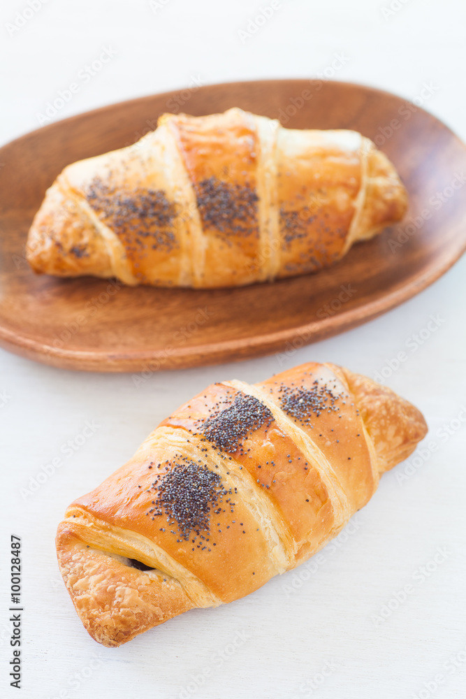 Fresh and tasty croissant on white wood table