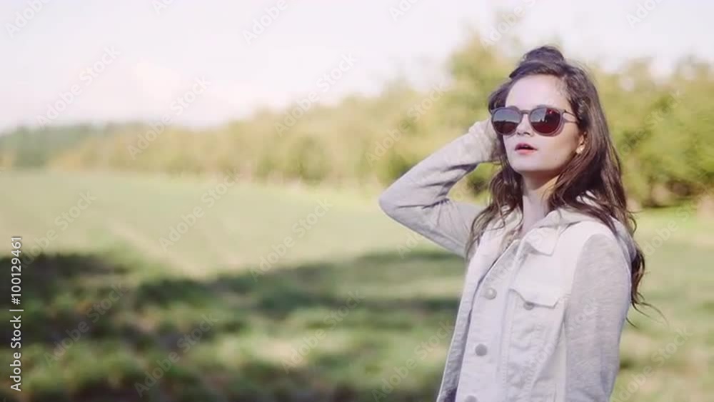 Beautiful girl wearing sunglasses in a field, slow motion Beautiful girl wearing sunglasses in a field, slow motion