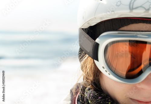 Young woman skier at winter ski resort in mountains, face close up