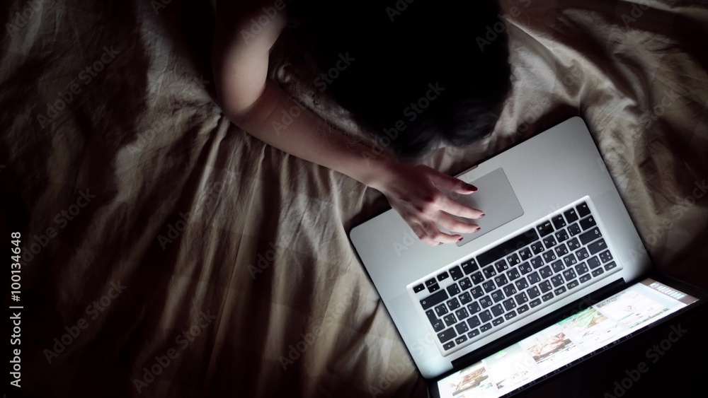 Happy young woman with laptop lying on bed. isolated on white Happy young woman with laptop lying on bed. isolated on white