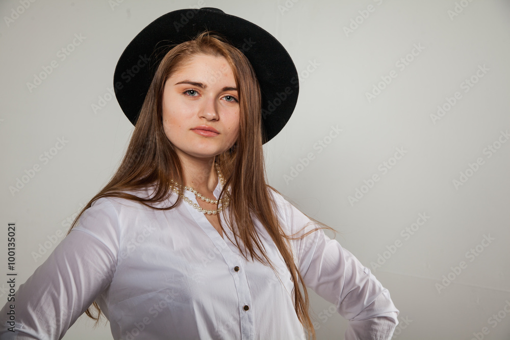 Awesome Caucasian attractive shy sexy female model with brunette hair posing on table in studio, wearing formal suit and hat, isolated on white background Awesome Caucasian attractive shy sexy female model with brunette hair posing on table in studio, wearing formal suit and hat, isolated on white background