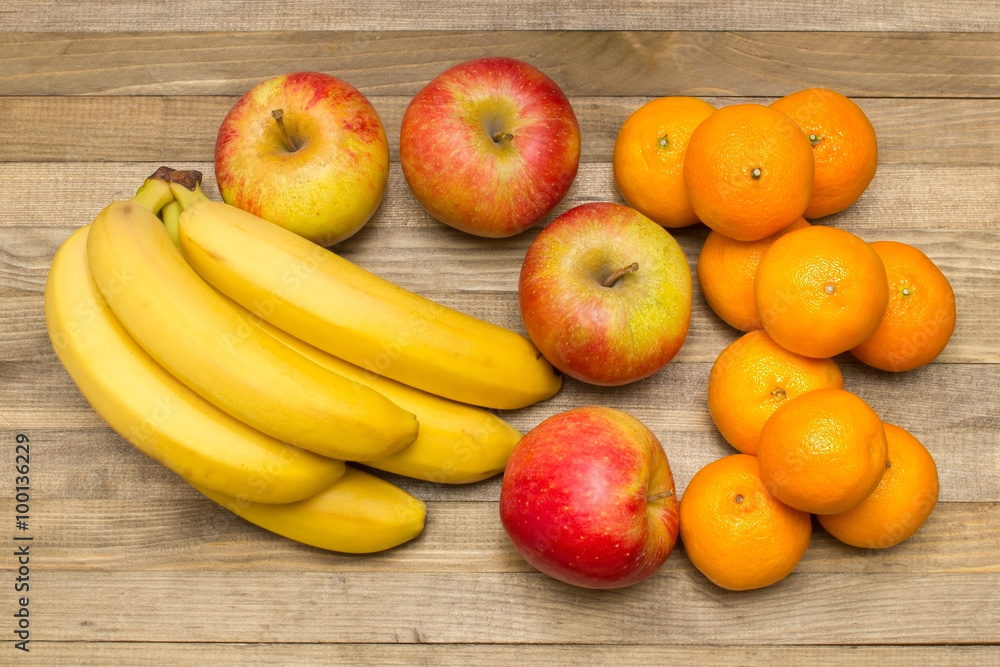 group of apple banana and mandarin fruits on wood group of apple banana and mandarin fruits on wood