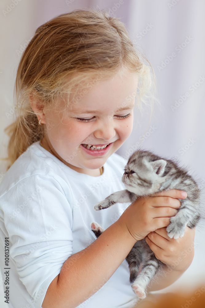 Little kid are playing with a kitten Little kid are playing with a kitten