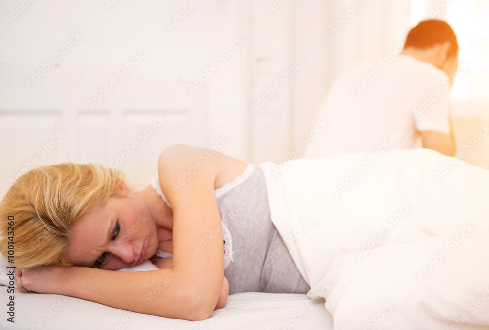 Young couple arguing on a bed cause of texts Young couple arguing on a bed cause of texts