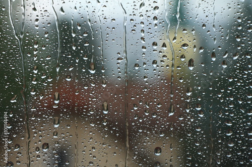 Rain drops on window with house and church in background