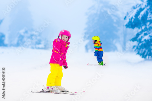 Two children skiing in snowy mountains