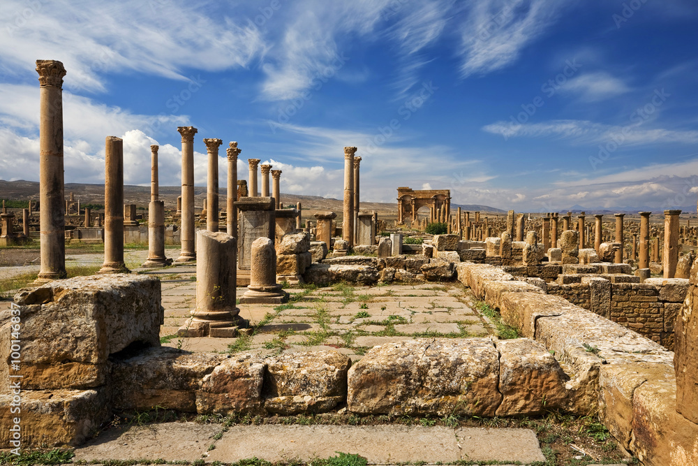 Algeria. Timgad (ancient Thamugadi or Thamugas). Row of columns at the forum and colonnade along Decumanus Maximus street terminated Trajan's Arch