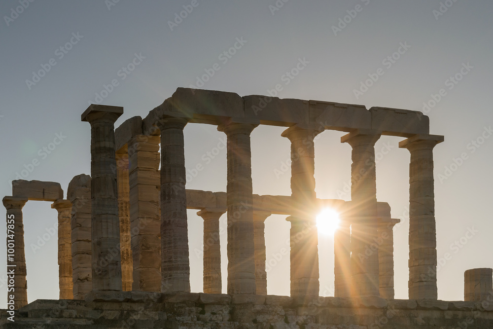 Temple of Poseidon silhouette in Sounio Greece against the sun rays.
