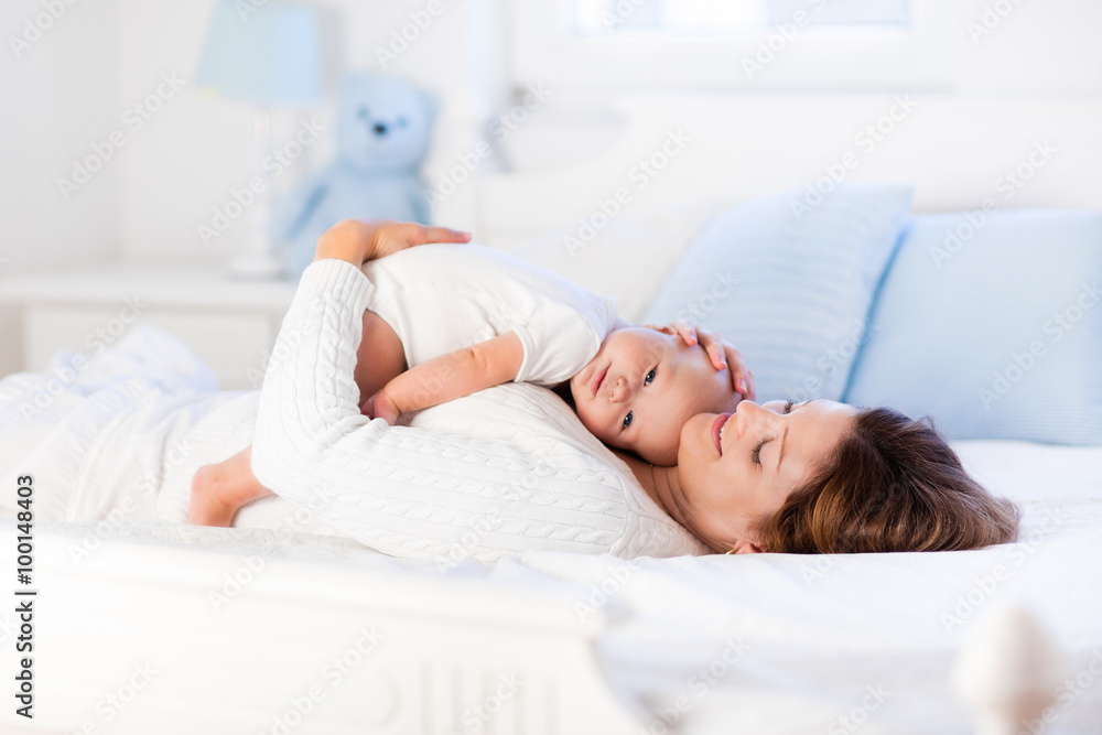 Mother and baby on a white bed Mother and baby on a white bed